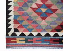 Handwoven Afghan Maimana kilim featuring a colorful geometric triangle pattern and fringed edges.