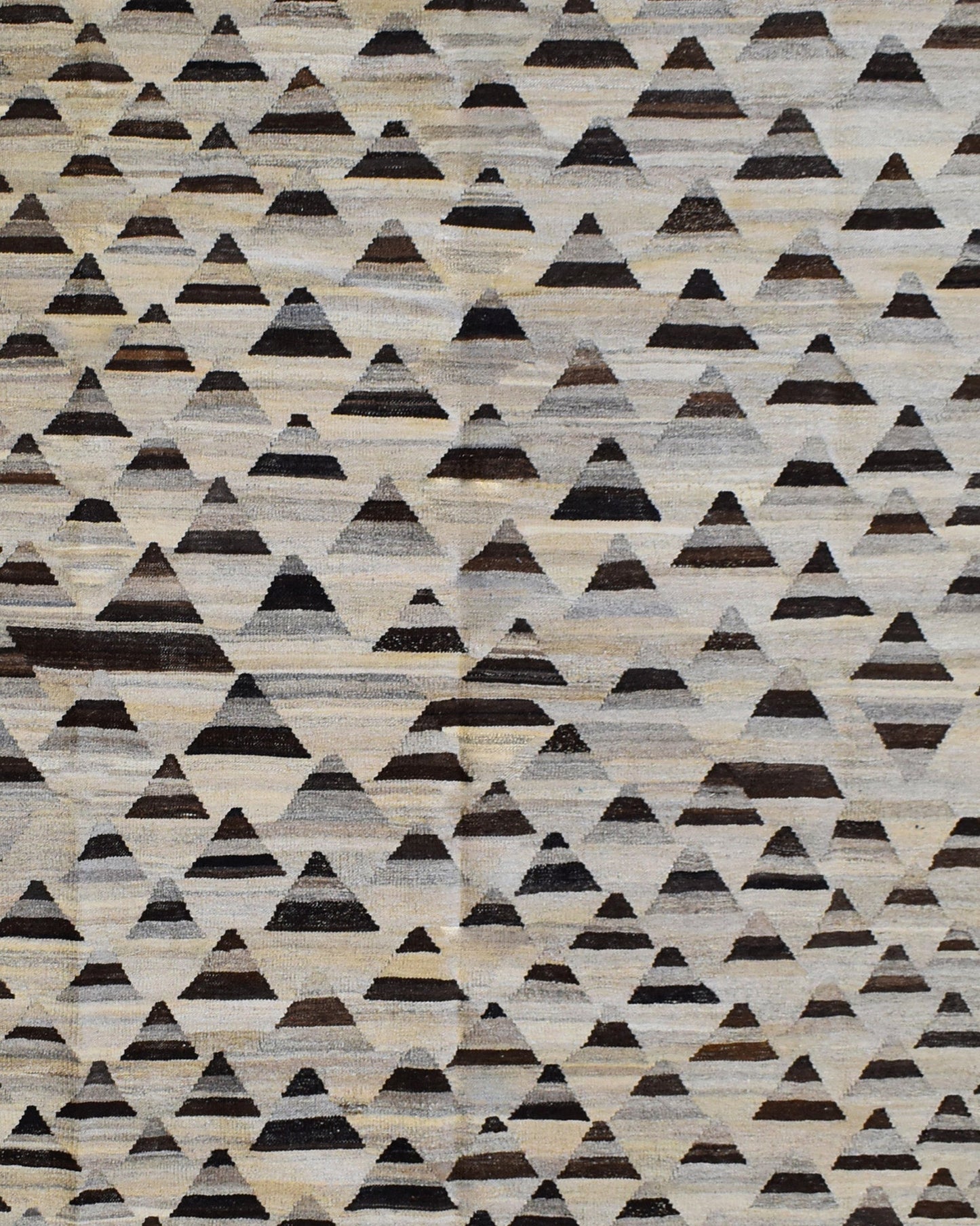 Handmade Afghan Maimana kilim rug featuring a repeating pattern of dark geometric triangles.