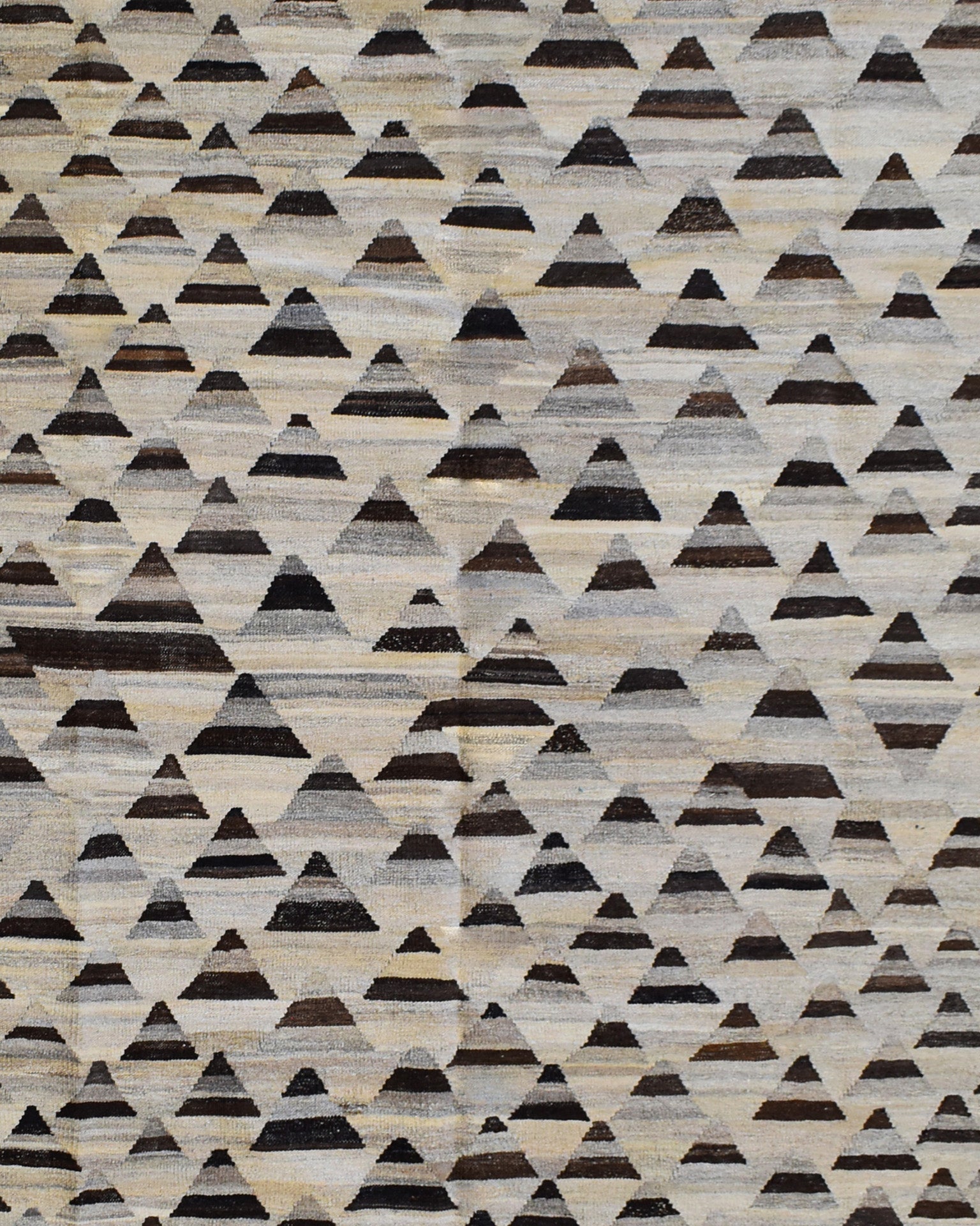 Handmade Afghan Maimana kilim rug featuring a repeating pattern of dark geometric triangles.