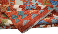 A handwoven Afghan Maimana kilim rug featuring a geometric pattern in vibrant, multi-colored wool.