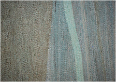 A close-up of a handmade Afghan Maimana wool kilim featuring a flat-weave texture in green tones.