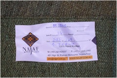 A close-up view of a green hand-knotted Afghan Maimana Kilim rug with an attached product tag.