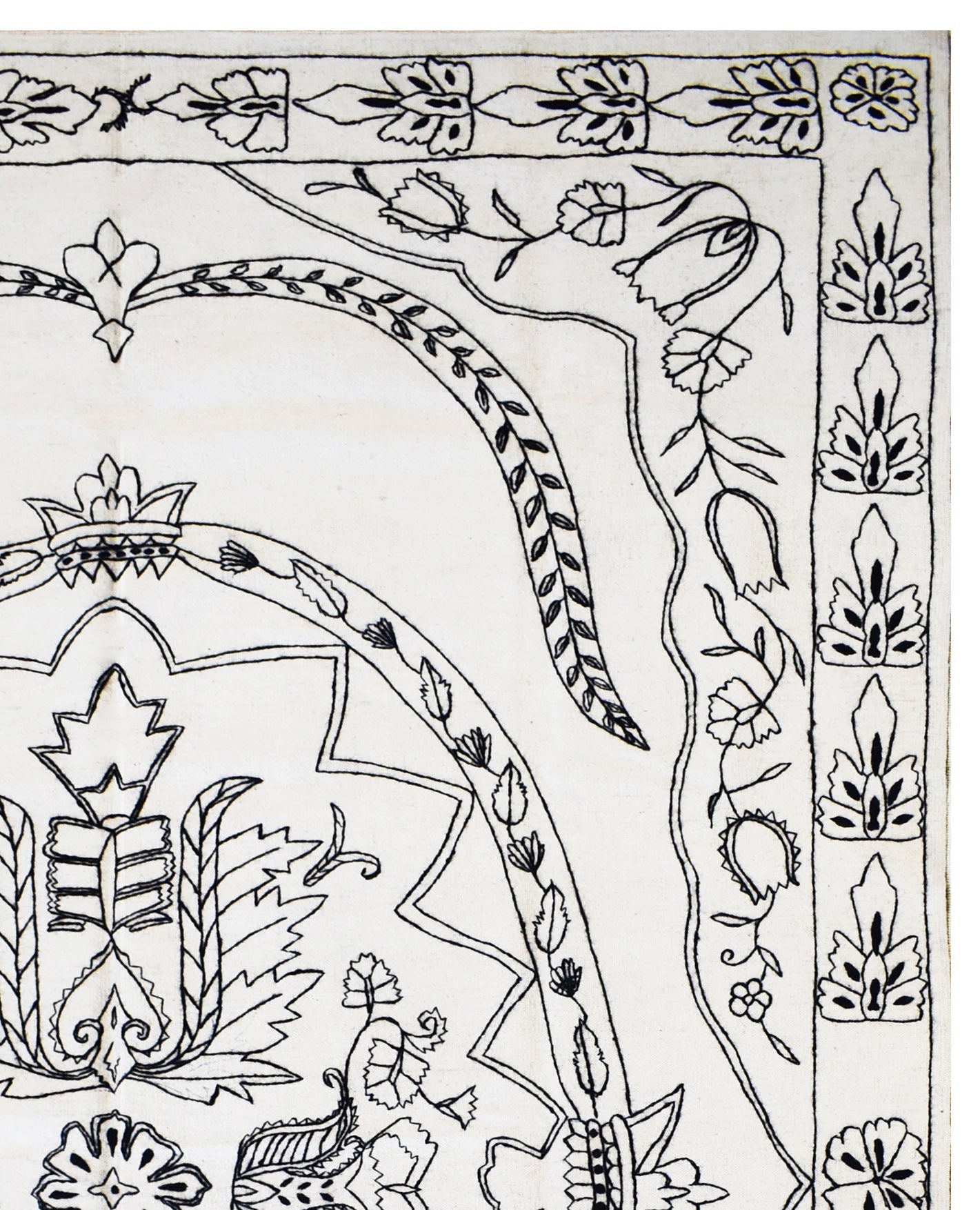 A close-up of a white wool kilim featuring intricate black hand-embroidered floral patterns.