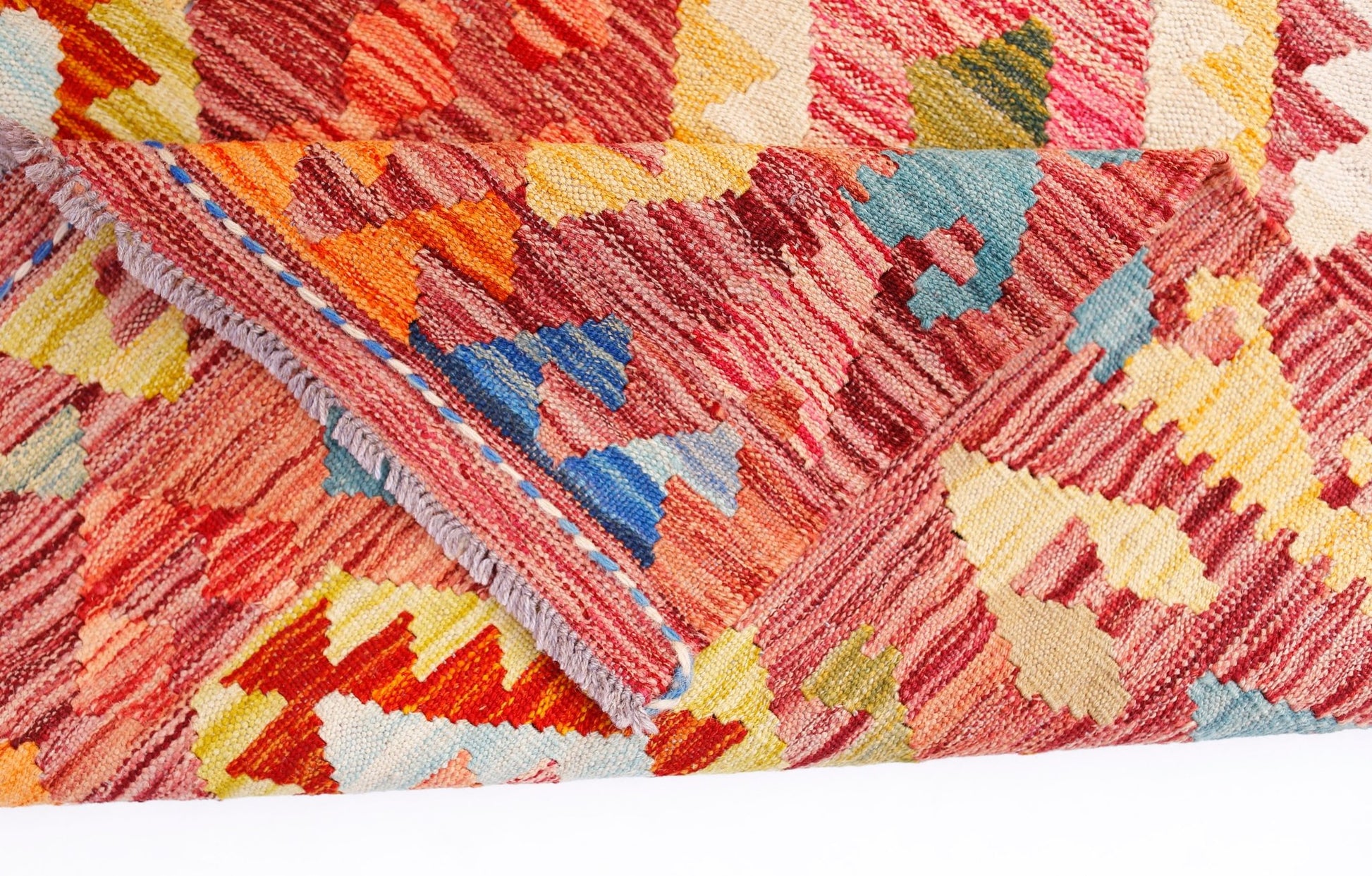 A handwoven Afghan Maimana kilim rug featuring a vibrant geometric pattern in wool.