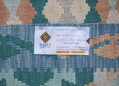 An Afghan Maimana Kilim rug featuring a geometric pattern in shades of blue, cream, and peach.