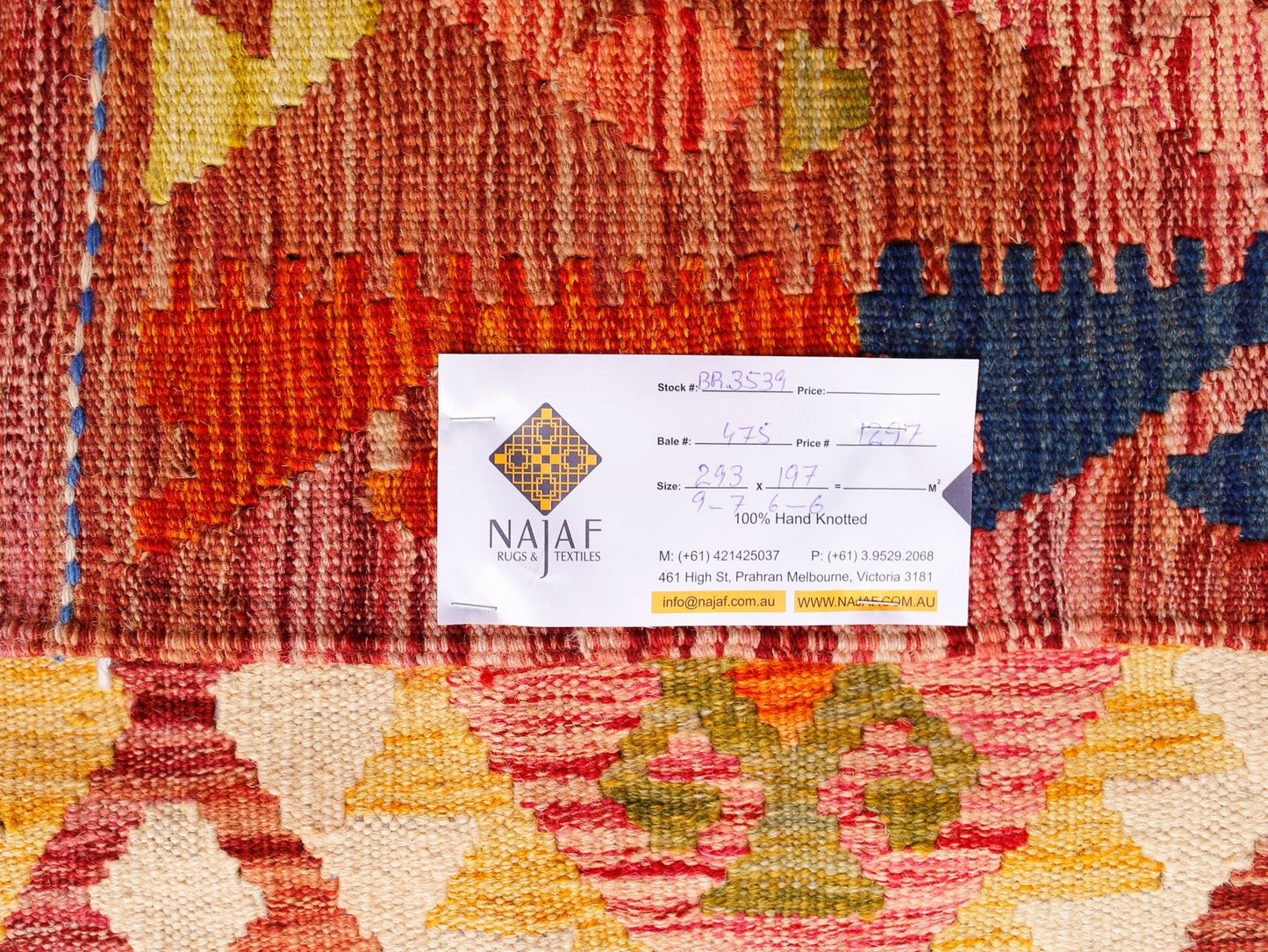 A handwoven Afghan Maimana kilim featuring a geometric pattern in warm red, yellow, and blue tones.