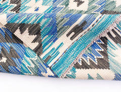 A handwoven Afghan Maimana kilim rug featuring a geometric pattern in shades of blue and cream.