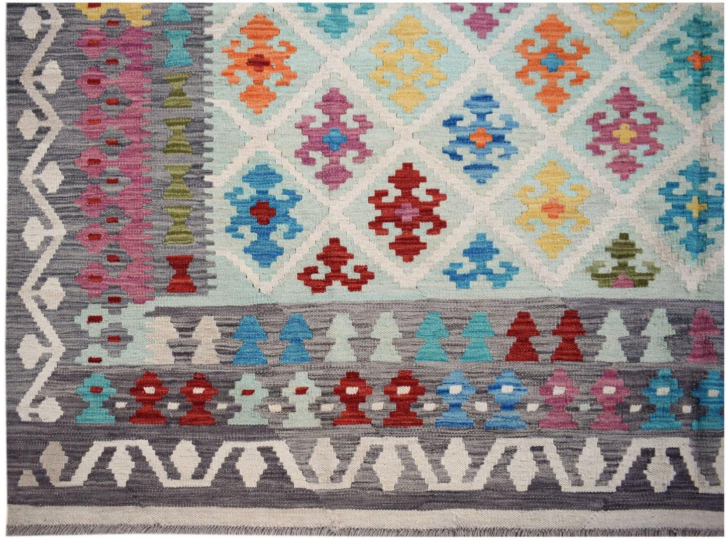 Handwoven Afghan Maimana kilim featuring a geometric diamond pattern in vibrant multicolored wool.