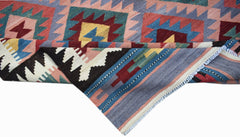 A handmade Afghan Maimana kilim rug featuring geometric patterns in red, blue, and yellow wool.