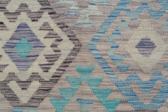 A handwoven Afghan Maimana kilim rug featuring a geometric pattern in shades of blue and grey.