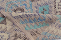 A handwoven Afghan Maimana kilim rug featuring geometric patterns in blue, teal, and beige tones.