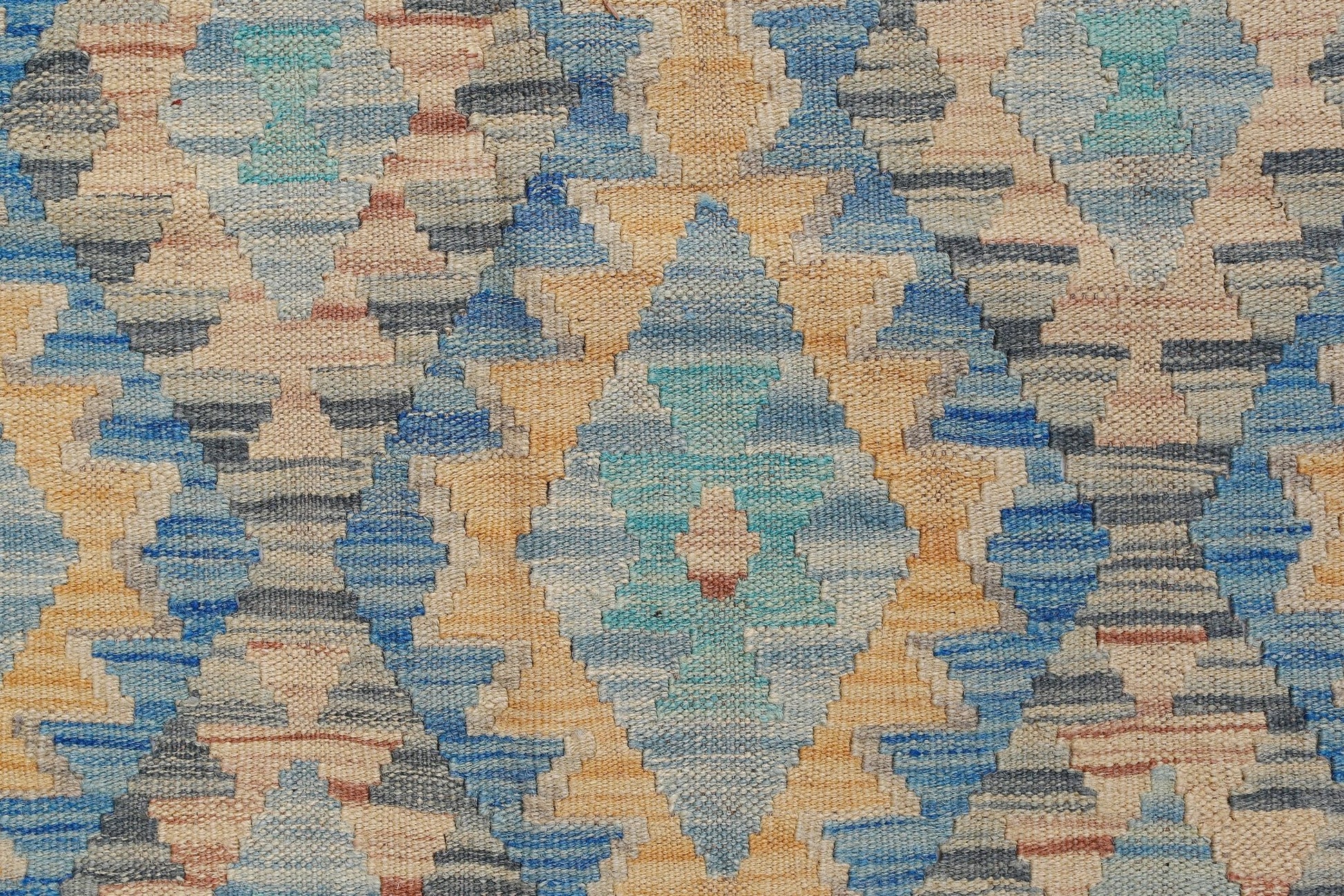 Handwoven Afghan Maimana kilim featuring a geometric diamond pattern in blue, tan, and grey tones.