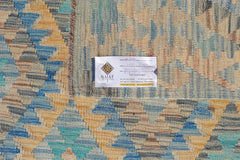 An Afghan Maimana Kilim rug featuring a geometric pattern in shades of blue, tan, and grey.