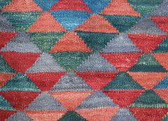 Handwoven Afghan Maimana kilim featuring a repeating geometric pattern of multicolored triangles.