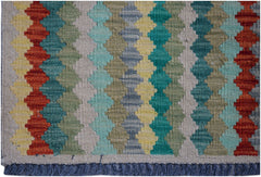 Handwoven Afghan Maimana kilim rug featuring a colorful geometric pattern and fringed edges.