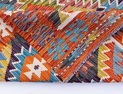 A handwoven Afghan Maimana kilim featuring a vibrant geometric pattern in wool.