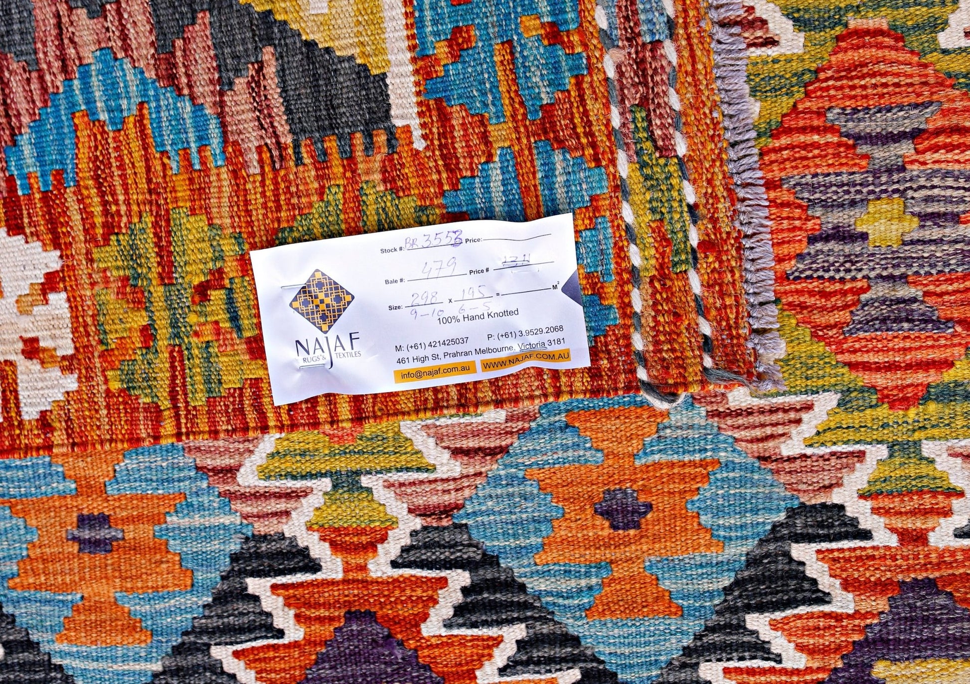 A handwoven Afghan Maimana kilim featuring a vibrant geometric pattern in wool.