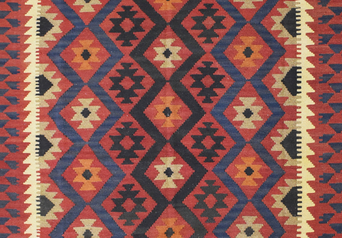 Handmade Afghan Maimana kilim rug featuring a geometric diamond pattern in red, blue, and tan.