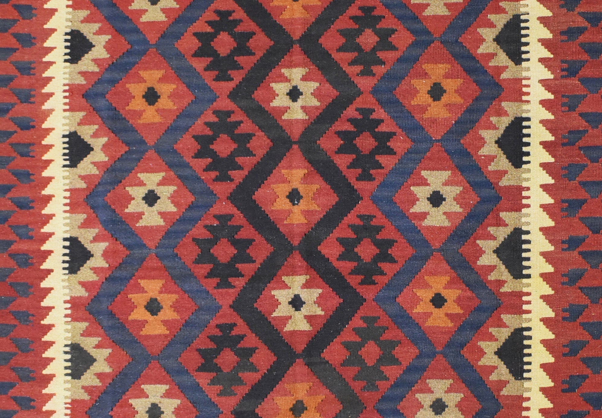 Handmade Afghan Maimana kilim rug featuring a geometric diamond pattern in red, blue, and tan.