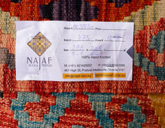 A handwoven Afghan Maimana kilim featuring a vibrant geometric pattern in red, blue, and orange.