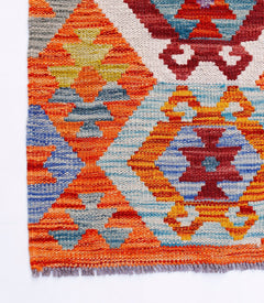 Handwoven Afghan Maimana kilim featuring a vibrant geometric pattern in wool.