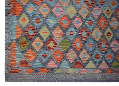 Handwoven Afghan Maimana kilim rug featuring a colorful geometric diamond pattern on a dark base.