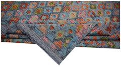 A handmade Afghan Maimana kilim rug featuring a colorful geometric diamond pattern on a grey base.