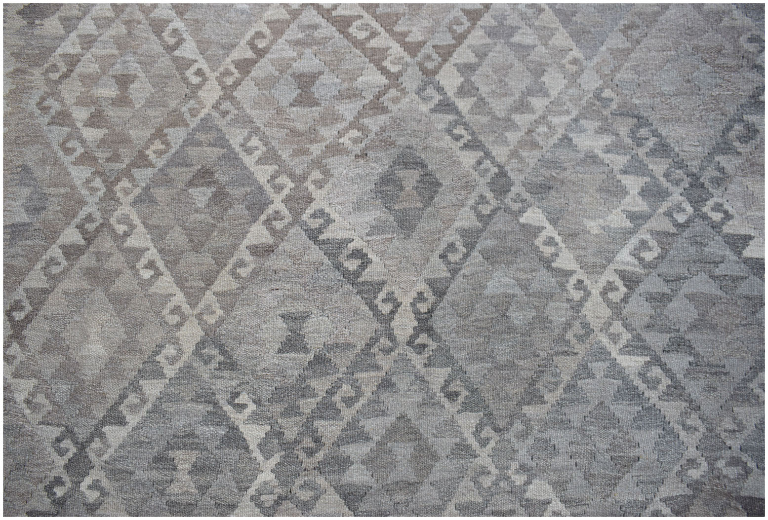 Handwoven Afghan Maiamana kilim rug featuring a grey and beige geometric diamond pattern.