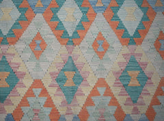 Handwoven Afghan Maimana kilim rug featuring a repeating geometric diamond pattern in soft colors.