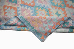 A handmade Afghan Maimana kilim rug featuring a colorful geometric pattern in a flatweave wool.
