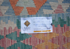 An Afghan Maimana kilim rug featuring a geometric pattern in shades of blue, pink, and orange.