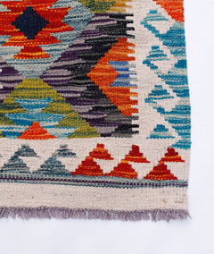 Handwoven Afghan Maimana kilim rug featuring a vibrant geometric pattern in wool.