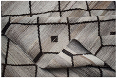 A handmade Afghan Maimana kilim featuring a neutral geometric grid pattern with small dark accents.