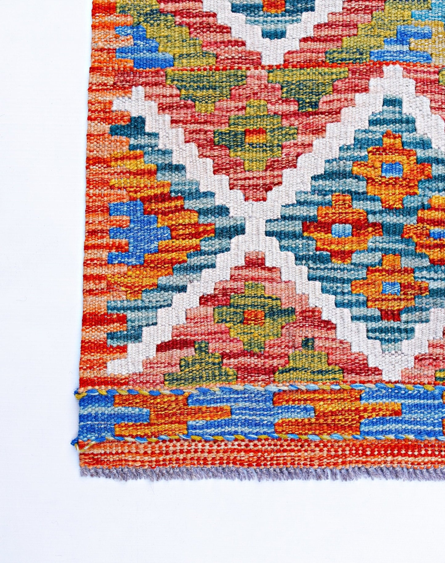 Handwoven Afghan Maimana kilim featuring a vibrant geometric pattern in wool.
