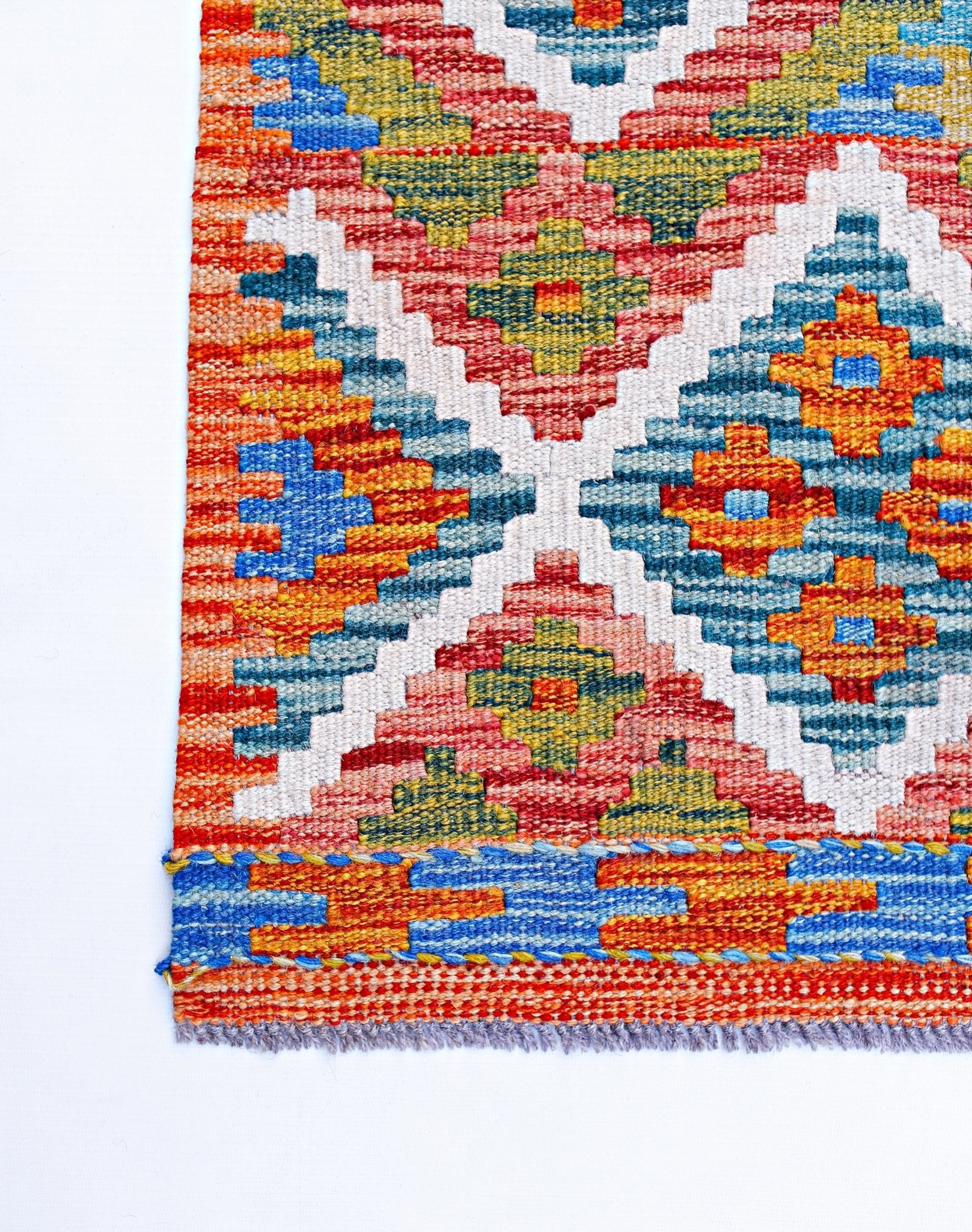 Handwoven Afghan Maimana kilim featuring a vibrant geometric pattern in wool.
