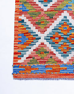 Handwoven Afghan Maimana kilim featuring a vibrant geometric pattern in wool.
