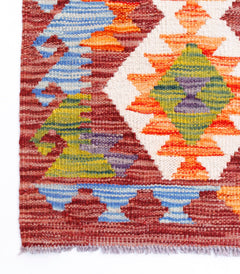 Handwoven Afghan Maimana kilim featuring a geometric pattern in vibrant multicolored wool.