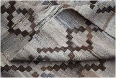 A handwoven Afghan Maimana kilim featuring a geometric pattern in shades of brown and beige.