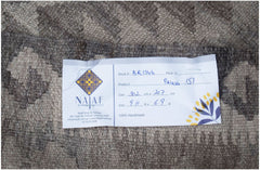 A handmade Afghan Maimana kilim featuring a neutral-toned geometric pattern.
