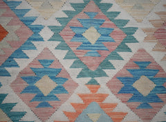 Handwoven Afghan Maimana kilim rug featuring a geometric diamond pattern in blue, pink, and orange.