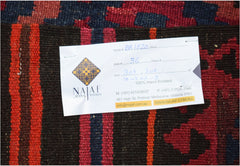 A handwoven Afghan Maimana kilim featuring a geometric pattern in deep red, blue, and brown tones.
