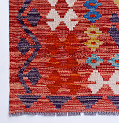 Handwoven Afghan Maimana kilim featuring a geometric pattern in red, blue, and cream wool.
