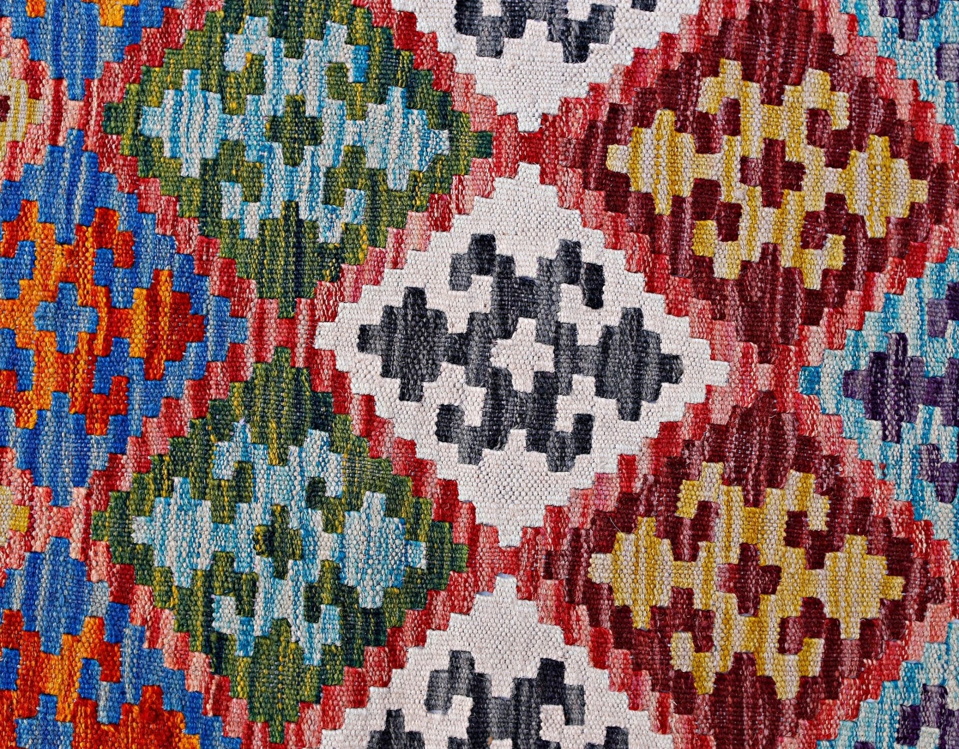 Handwoven Afghan Maimana kilim featuring a vibrant geometric pattern in wool.