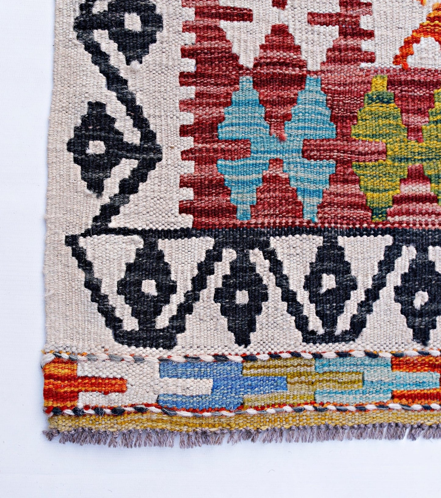 Handwoven Afghan Maimana kilim featuring geometric patterns in red, blue, yellow, and black wool.