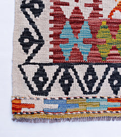 Handwoven Afghan Maimana kilim featuring geometric patterns in red, blue, yellow, and black wool.