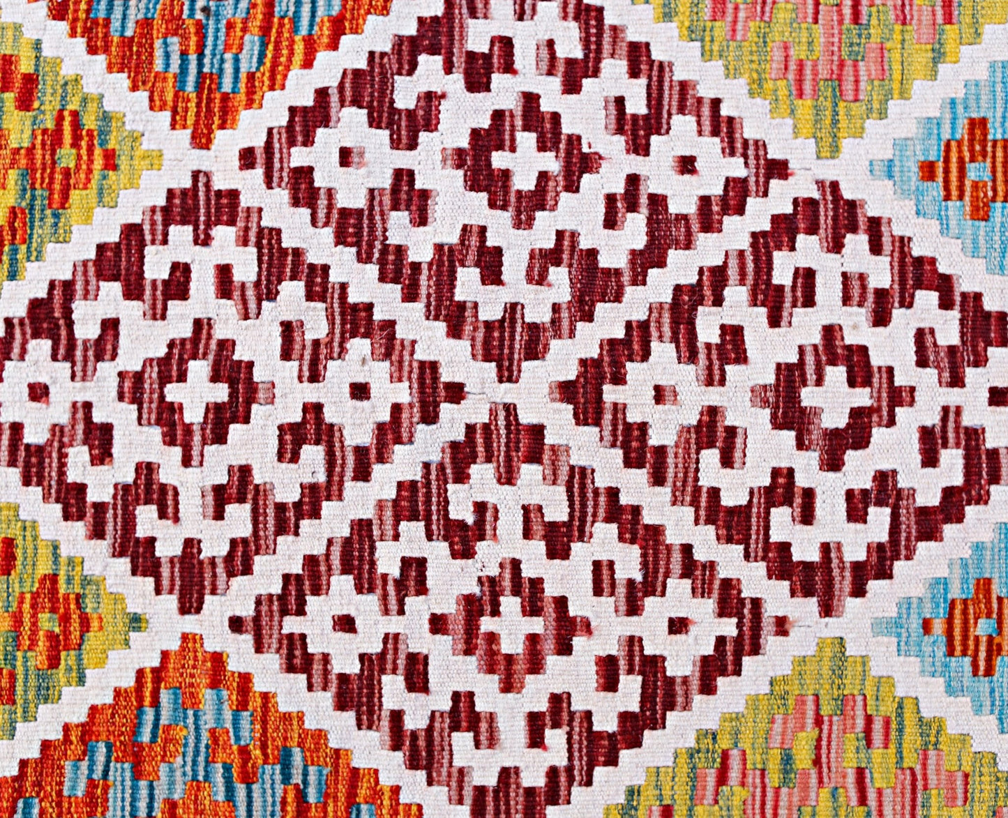 Handwoven Afghan Maimana kilim featuring a geometric pattern in red, white, yellow, and blue.