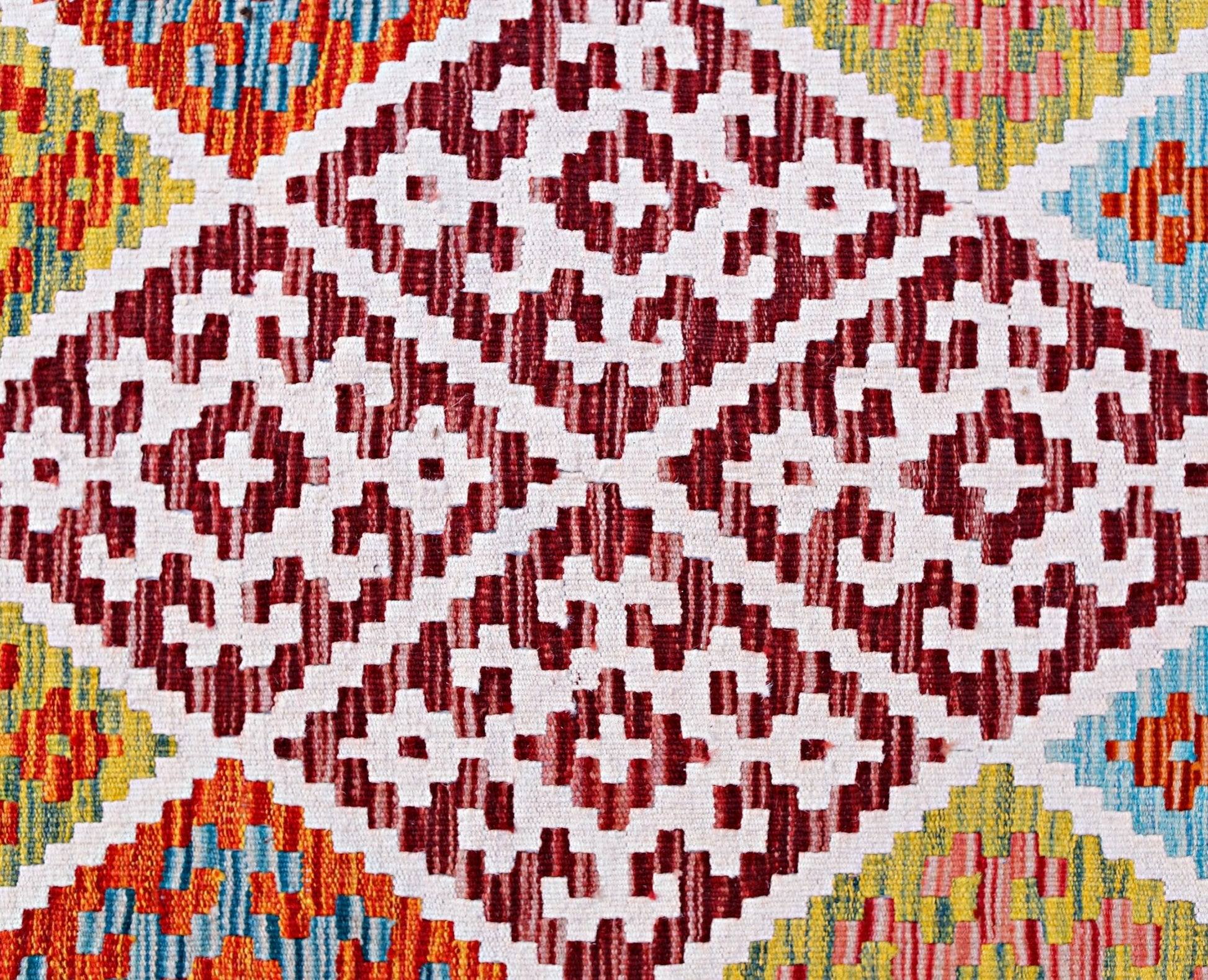 Handwoven Afghan Maimana kilim featuring a geometric pattern in red, white, yellow, and blue.