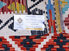 A handwoven Afghan Maimana kilim featuring a vibrant geometric pattern in red, blue, and yellow.