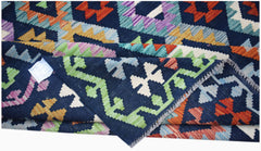 A handwoven Afghan Maimana kilim rug featuring a geometric pattern in vibrant multicolored wool.
