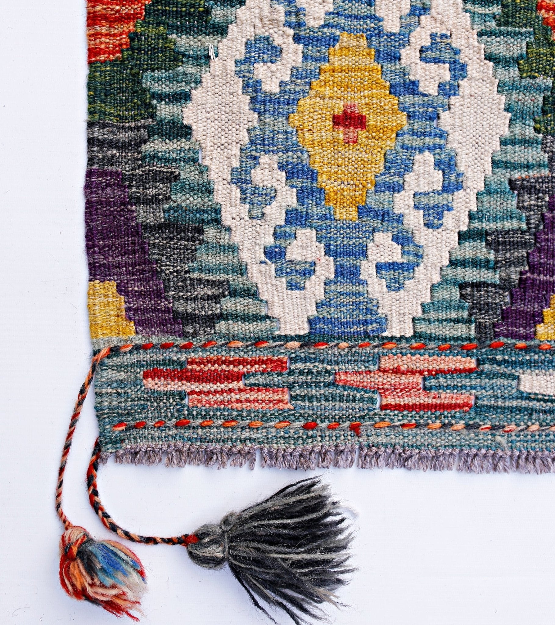 Handwoven Afghan Maimana kilim featuring a geometric pattern in blue, yellow, and red wool.